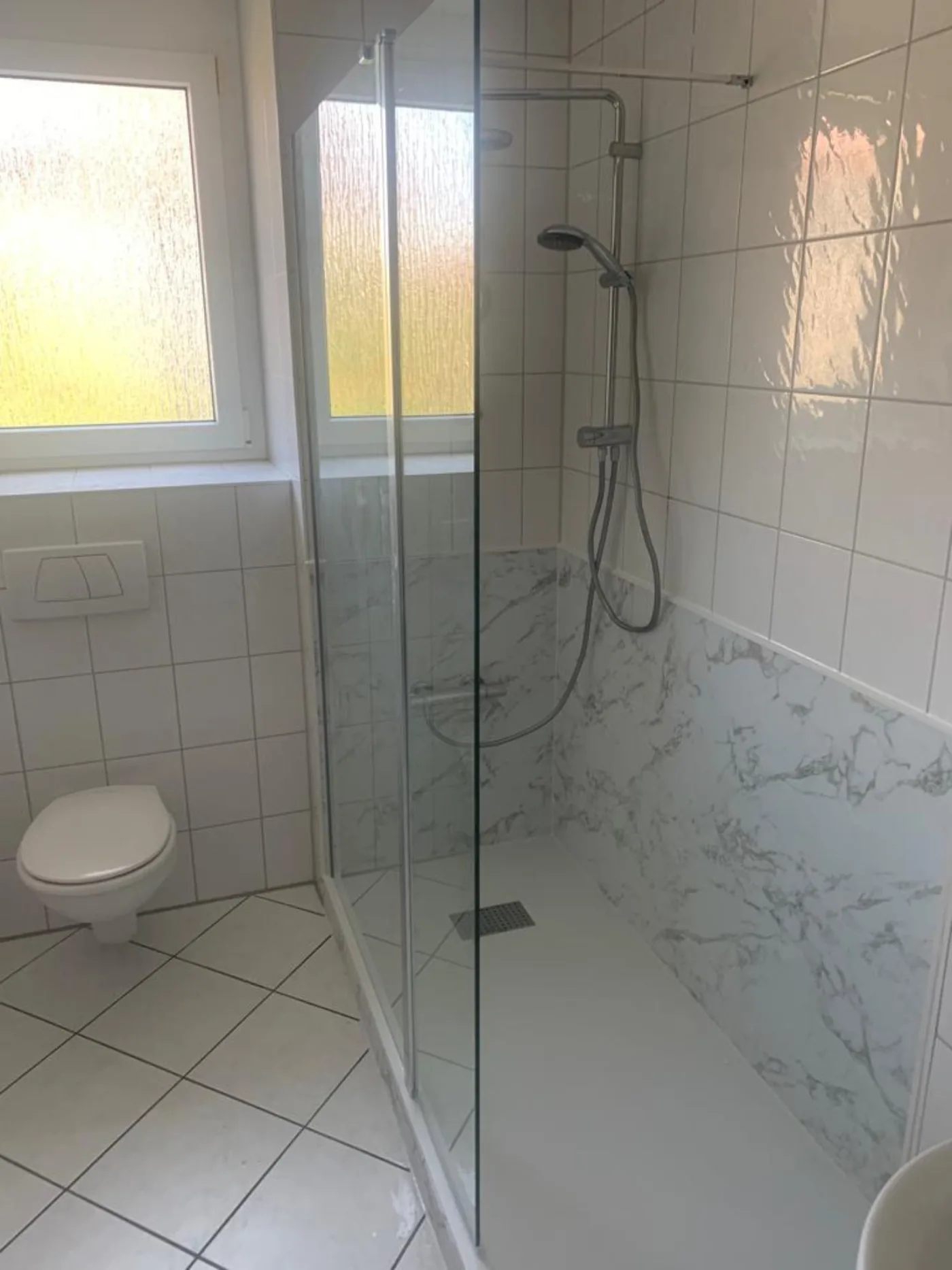 Dusche mit hellen Wandpaneelen in Marmoroptik