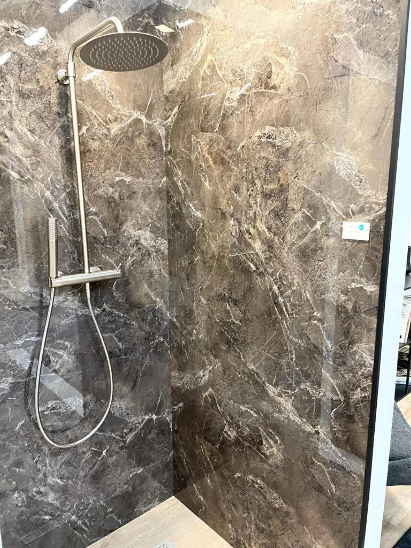Dusche mit dunklem großformatigem Wandpaneel und Regenbrause